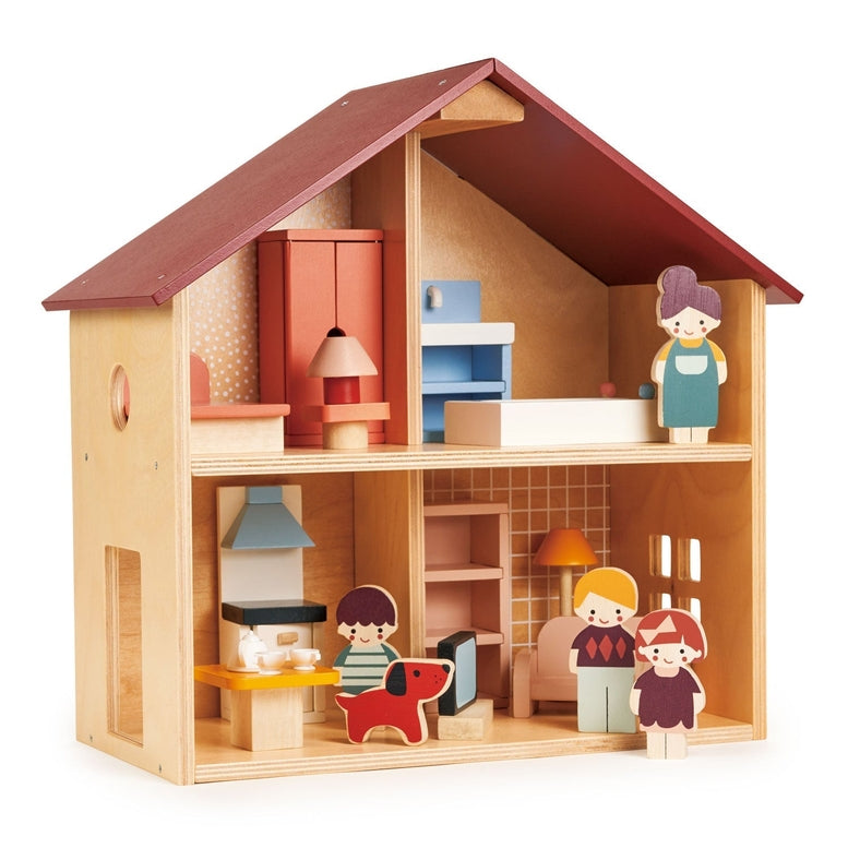 An open-faced wooden dollhouse by Mentari with a red roof and natural wood frame, arranged with miniature wooden furniture, a toy dog, and several wooden character figurines standing outside the rooms.