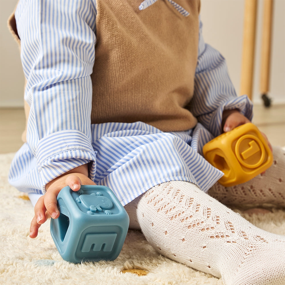 Child playing with colorful blocks on a carpeted floor