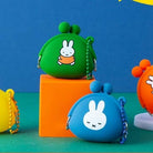 Two small pouches, one green and one blue, with cartoon character designs on a colorful background.