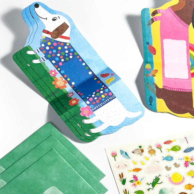 Colorful children's book with a dog illustration, green fabric, and sticker sheet on a white background