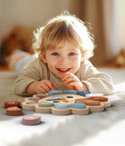 Child playing with a colorful wooden puzzle toy on a soft surface.