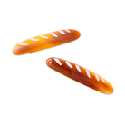 Two bread-shaped hair clips on a white background