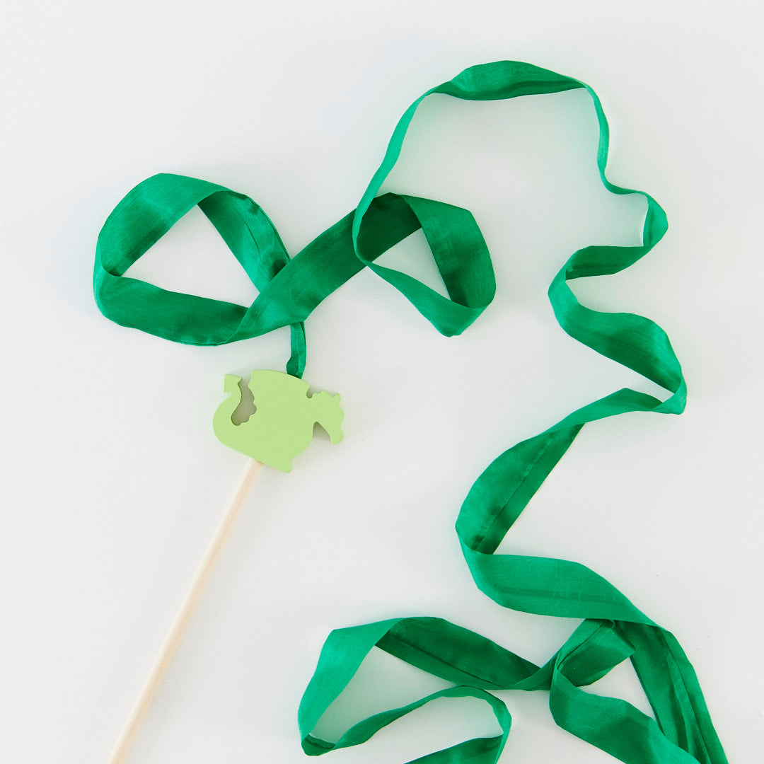 Green ribbon on a stick with a shamrock-shaped holder on a white background