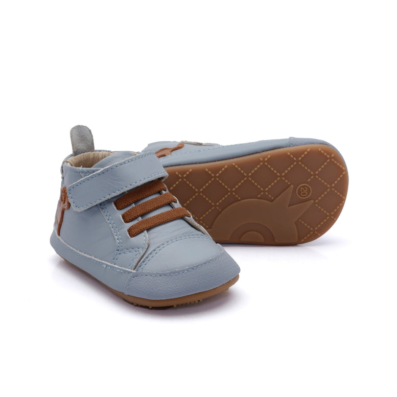 Pair of light blue children's shoes with brown soles on a white background