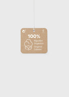 A square kraft paper hanging tag with rounded corners, printed with '100% Algodón Orgánico / Organic Cotton' and a cotton boll icon, suspended by a thin white string against a light gray background.