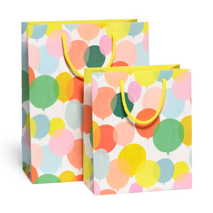 Two colorful gift bags with balloon pattern on a white background