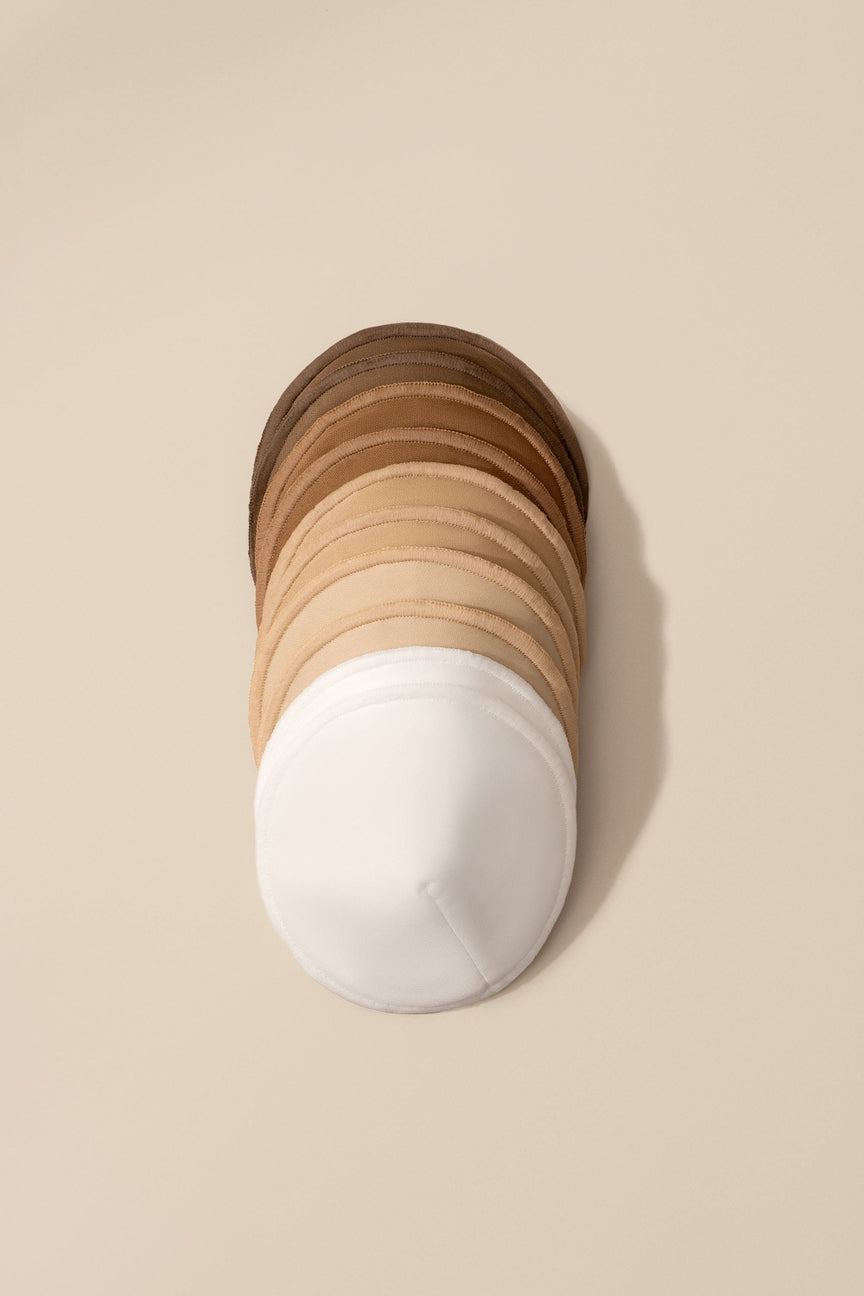 Stack of wooden coasters with a white base on a beige background