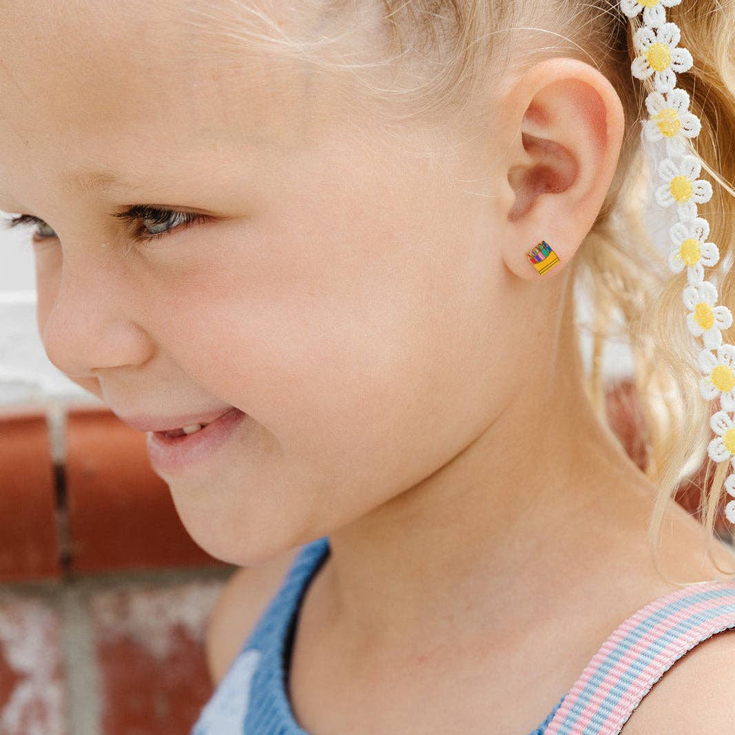 Close-up of a young girl wearing colorful earrings with a blurred background