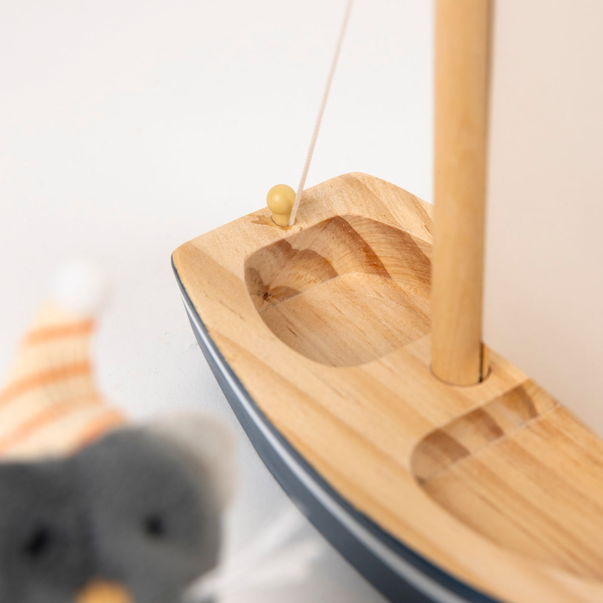 Wooden boat toy with a rope on a white background