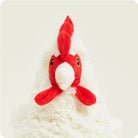A close-up of a fluffy white Warmies chicken plush toy, focusing on its bright red comb, wattle, and black button eyes against a plain white background.