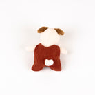 Stuffed toy dog with a red romper on a white background - from the back