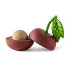 Red pepper-shaped container with gold lid and green leaf on a white background