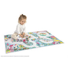 Child playing on a colorful play mat with road designs and small buildings.