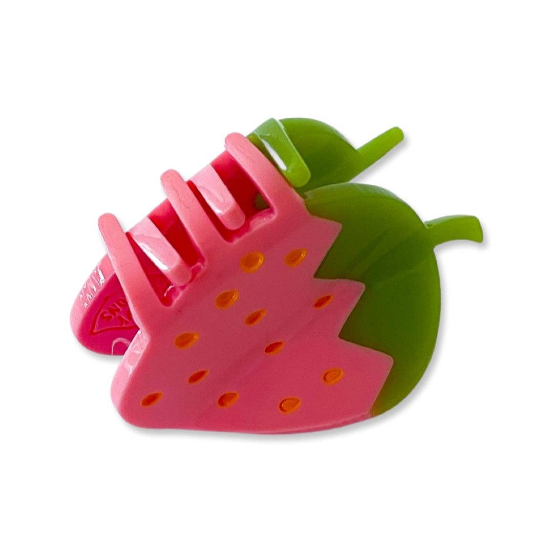 Pink strawberry-shaped comb with green leaves on a white background
