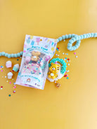 Toy packaging with a toy figure on a yellow background
