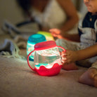 Children playing with colorful light-up toys on a soft surface