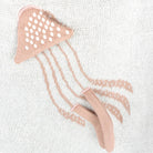 Pink jellyfish-shaped tool on a textured white background