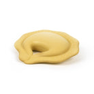 A pale yellow silicone teething toy shaped like a crescent moon with small raised dots along the outer edge, shown on a clean white background.