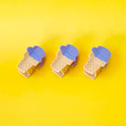 Three ice cream cone-shaped clips with blue lids on a yellow background