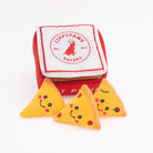 Three triangular pizza-shaped dog toys with smiley faces in front of a red and white Zippy Paws container.