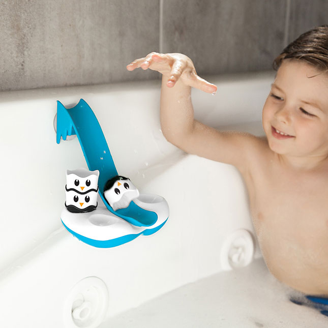 Child playing with penguin bath toy in a bathtub