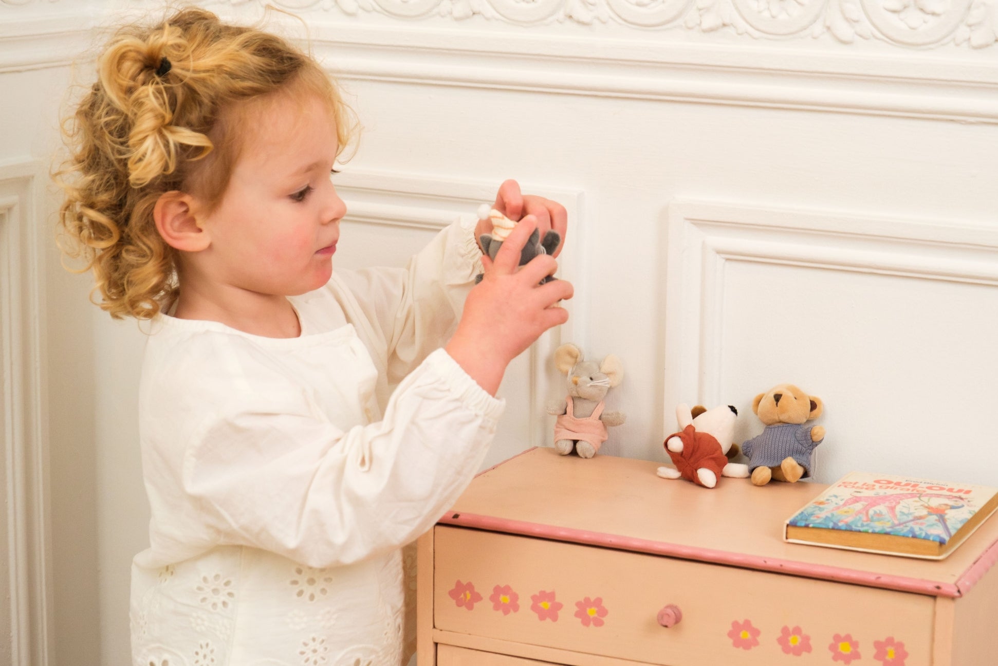 Child playing with a toy in a bedroom setting