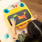 Child playing with a colorful educational toy on a wooden floor