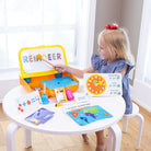 Child playing with educational toys at a small table in a bright room.