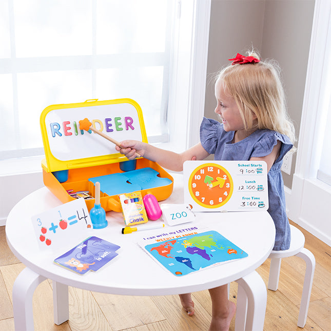 Child playing with educational toys at a small table in a bright room.