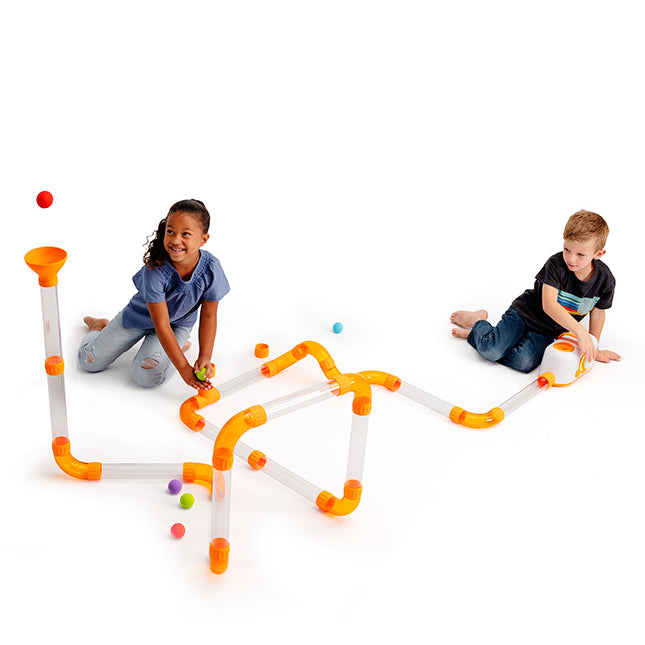 Two children playing with a marble run toy on a white background