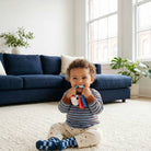 Child sitting on the floor in a living room holding a toy