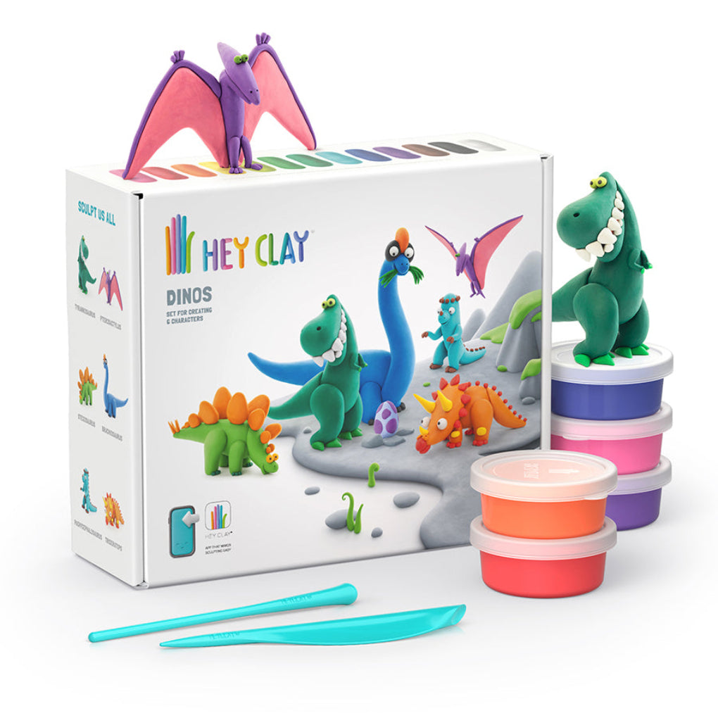 Hey Clay Dinos toy set with a white branded box, colorful clay pots, sculpting tools, and several dinosaur figures including a green T-Rex, blue Brachiosaurus, orange Stegosaurus, and purple Pteranodon, shown on a clean white background.
