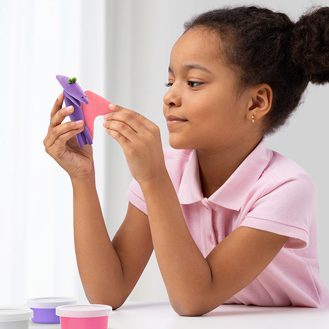Young girl playing with a toy on a white background