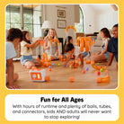 A group of children and an adult sitting on a wooden floor in a living room, playing with a large orange and clear marble-run style toy set with colorful balls. A text box at the bottom reads 'Fun for All Ages' and describes the toy's playful features.