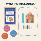 An included-items graphic for a Cotton Twist cross-stitch kit, titled 'WHAT'S INCLUDED?'. It shows the blue-and-brown product box, a wooden gingerbread house design, a blue ribbon, and thread spools, with circular labels naming the contents on a light beige background.