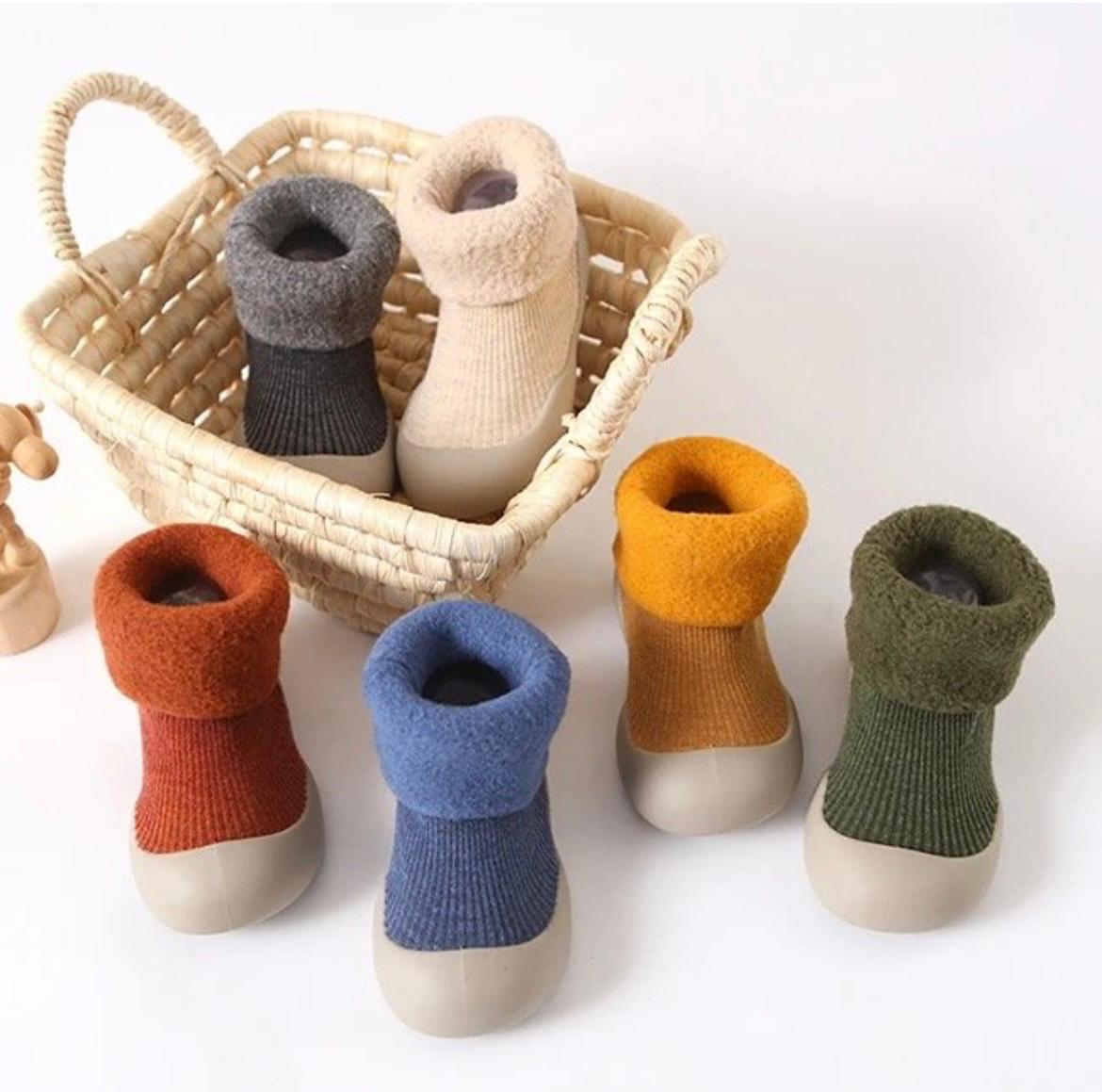Colorful baby socks with wooden soles displayed on a white background