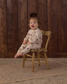 A toddler wearing the Rylee + Cru Spongey Knit Set in Petal Daisy featuring an all-over tiny floral print on soft beige knit fabric.