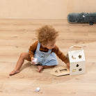 Child playing with wooden toys on a wooden floor