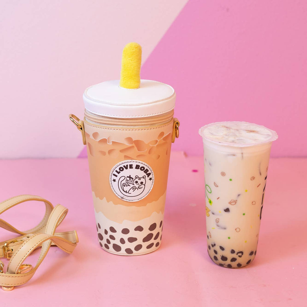 Boba tea with a straw and bubble tea in a clear cup on a pink background