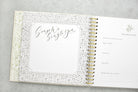 Open spiral-bound planner with decorative cover on a gray surface