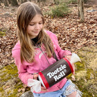 Girl holding a Tootsie Roll product in a forest setting