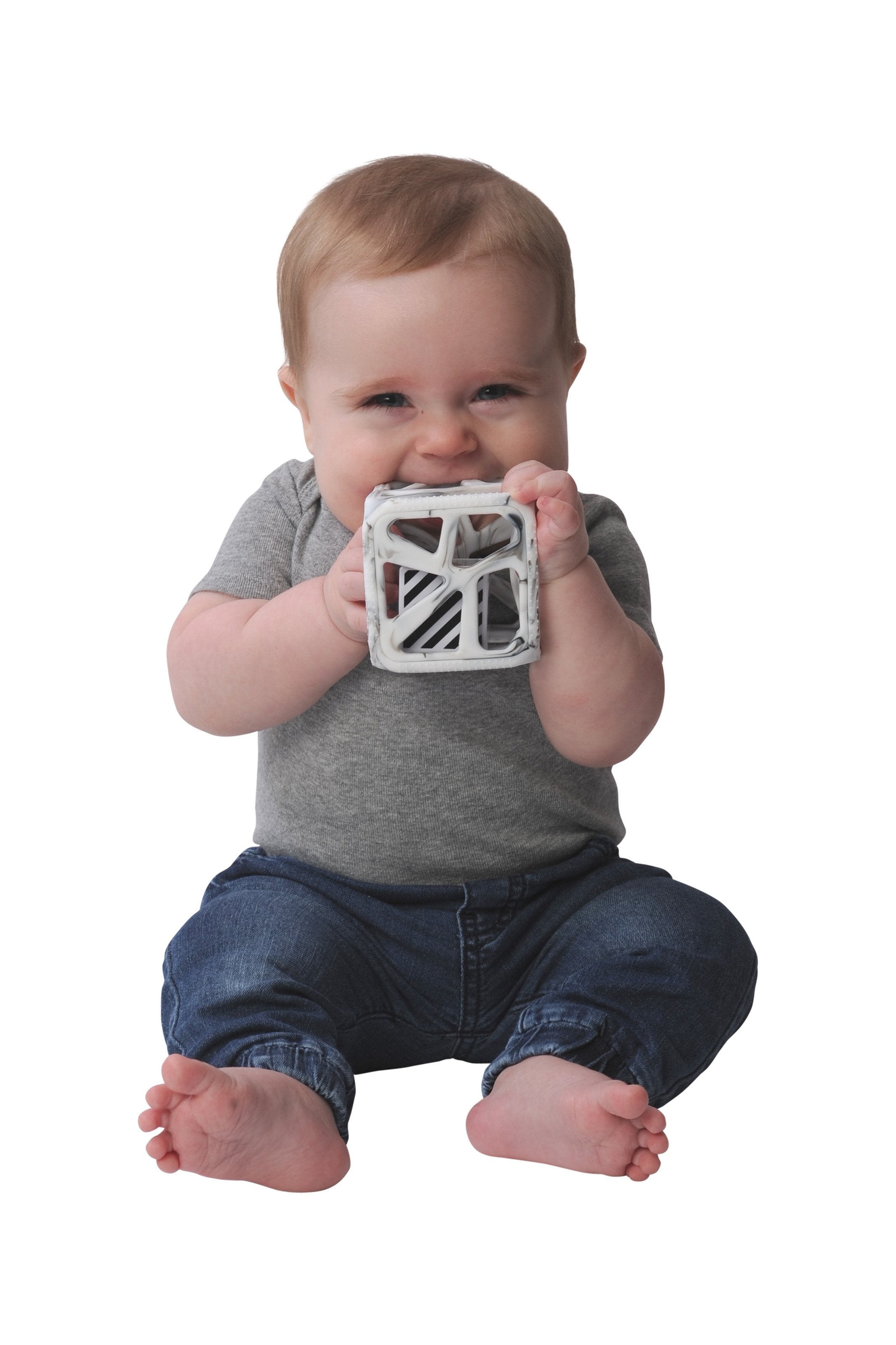 Baby holding a textured block against a white background