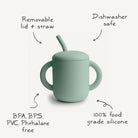Mint green sippy cup with a lid and straw on a white background, featuring text about its features.