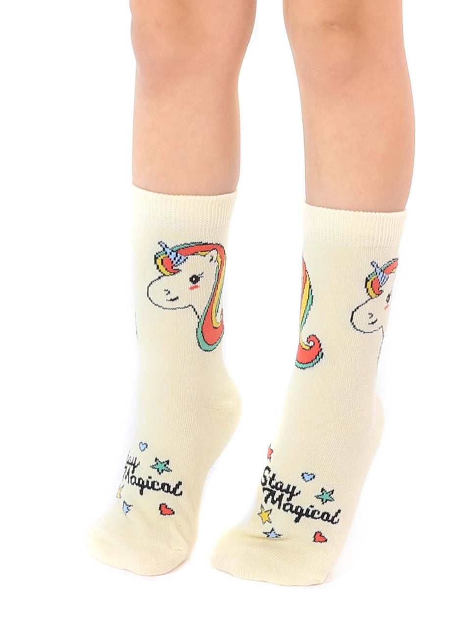 Cream-colored socks with unicorn design and 'Stay Magical' text worn by a person on a white background
