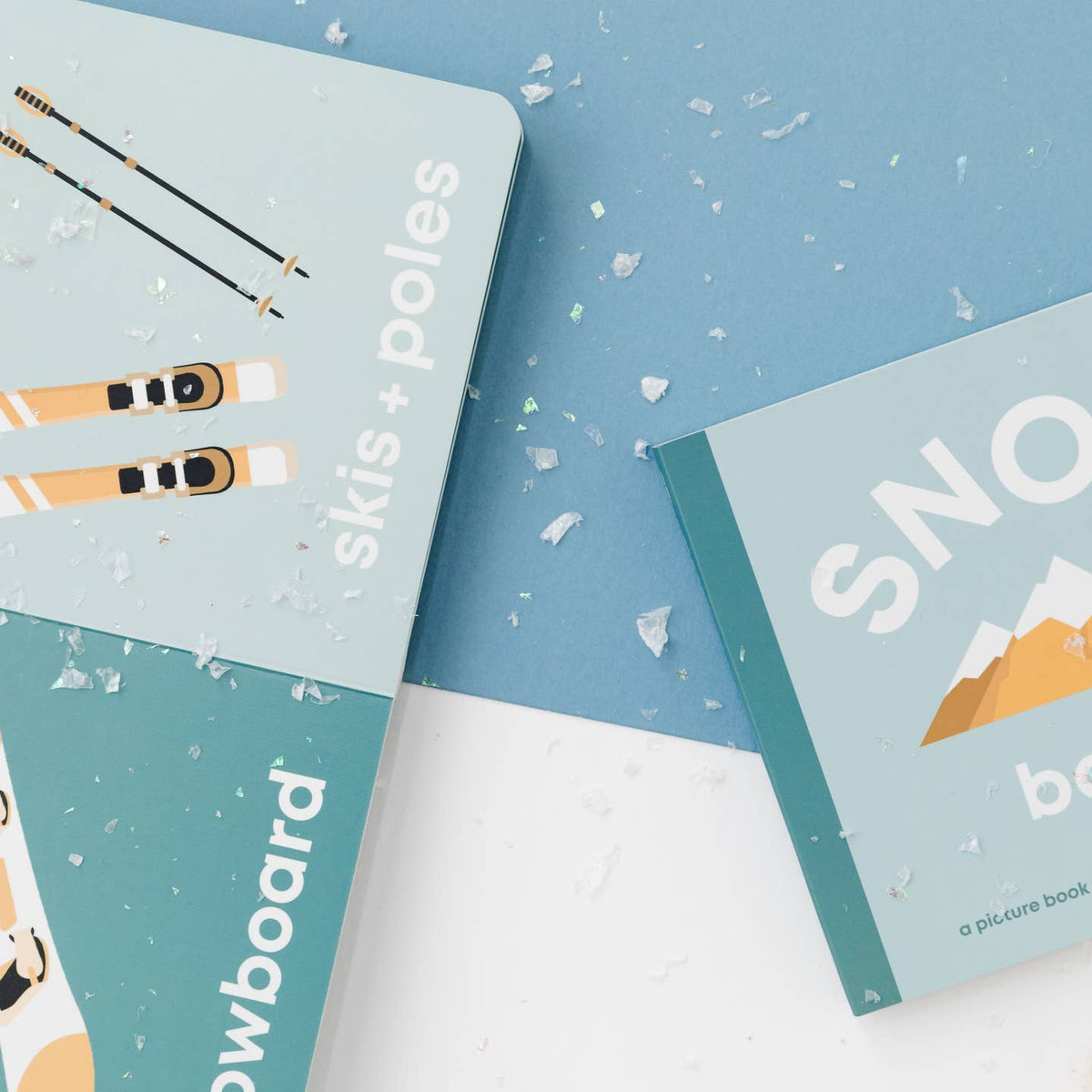 Two children's books on a blue background with snow-themed illustrations.