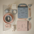 Collection of children's tableware and stationery items on a light background