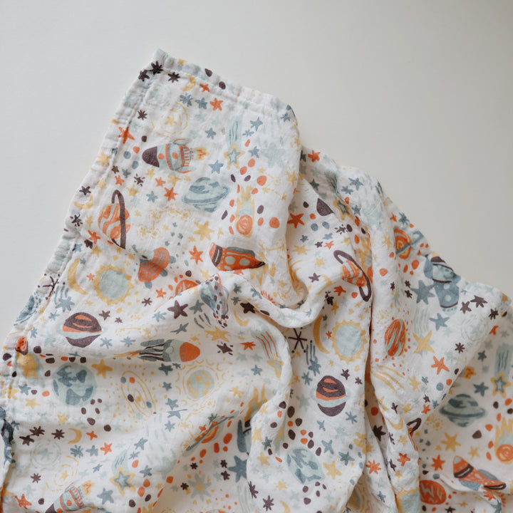 Folded fabric with space-themed pattern on a plain background