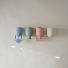 Four pastel-colored cups on a white surface