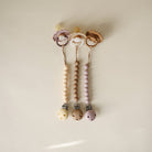 Three pacifier clips with wooden beads on a beige background