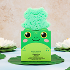 Green frog-shaped sponge with packaging on a light background